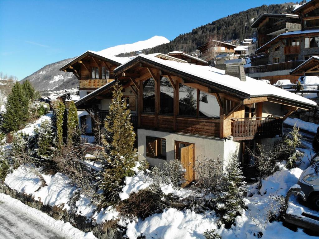 una casa su un pendio innevato con una montagna di Chalet Sosa a Morzine