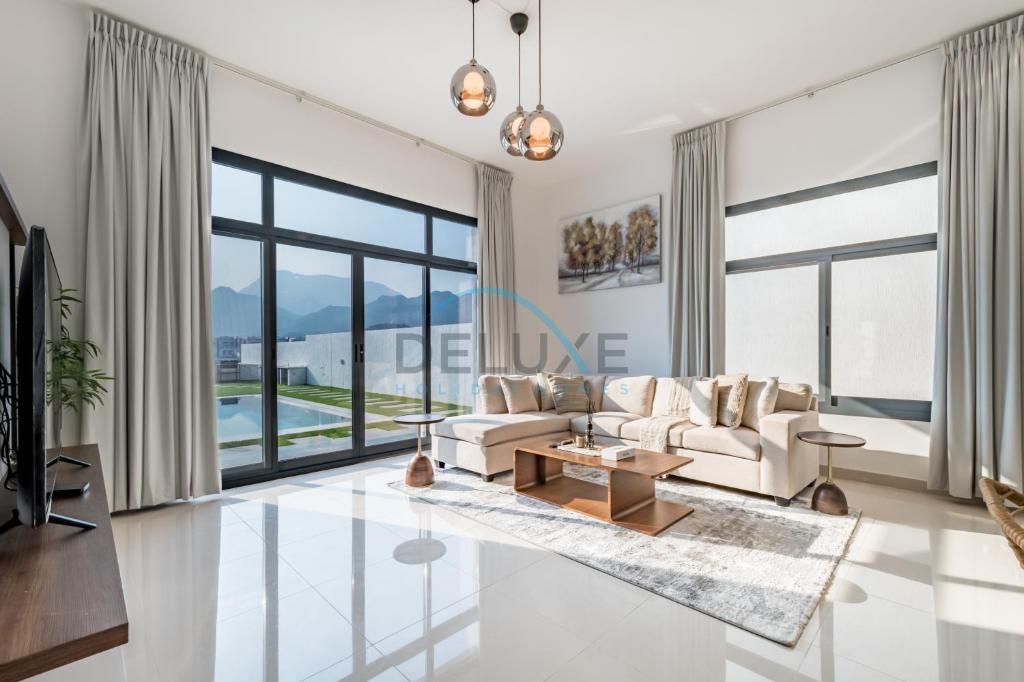 a living room with a couch and a table at Serene Island Getaway 3BR Villa with Assistant Room Al Dana Island, Fujairah by Deluxe Holiday Homes in Fujairah