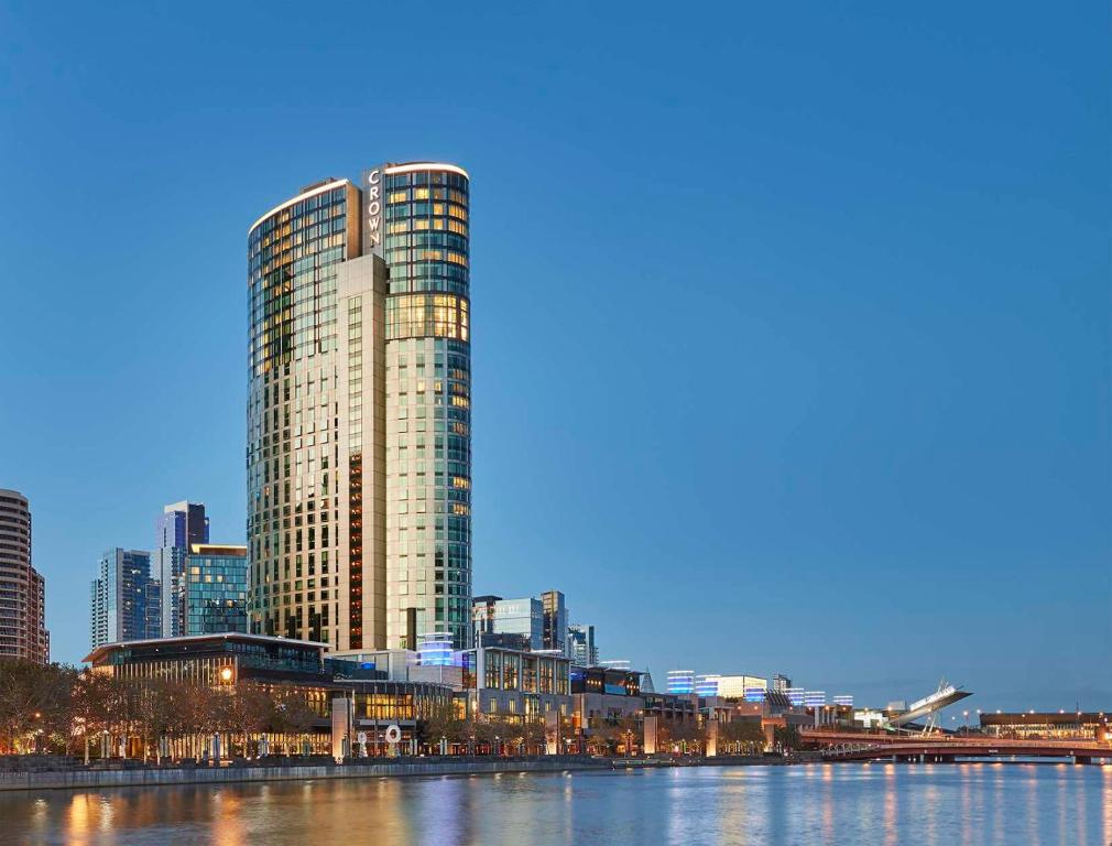 wysoki budynek obok rzeki z miastem w obiekcie Crown Towers Melbourne w Melbourne