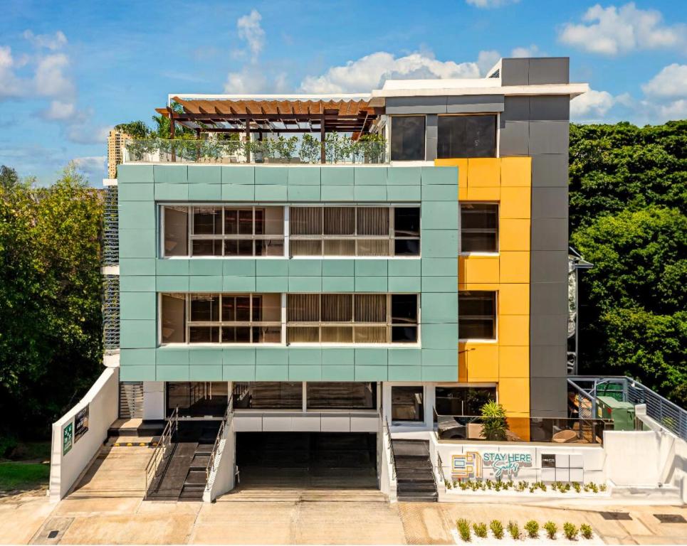 um edifício com uma fachada azul e amarela em Hotel Stay Here Suites em Santo Domingo