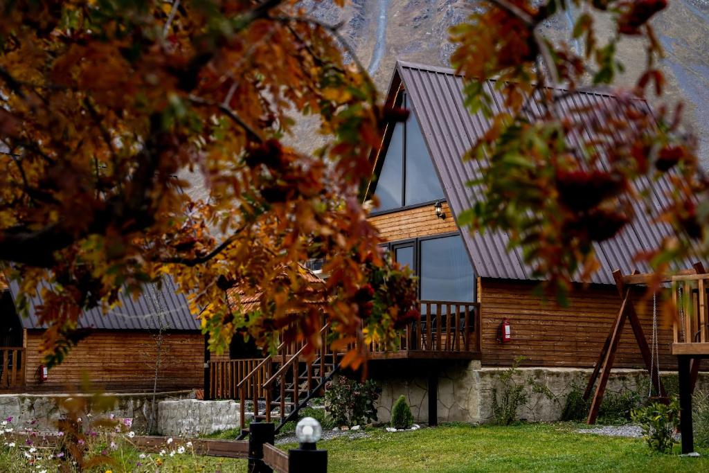 ein Haus mit einem Metalldach und einer Treppe in der Unterkunft Hillside Kazbegi in Kazbegi