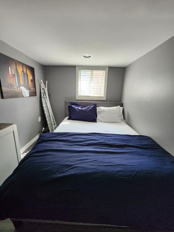 una camera da letto con un grande letto con lenzuola blu di Jakpor Residence a Windsor