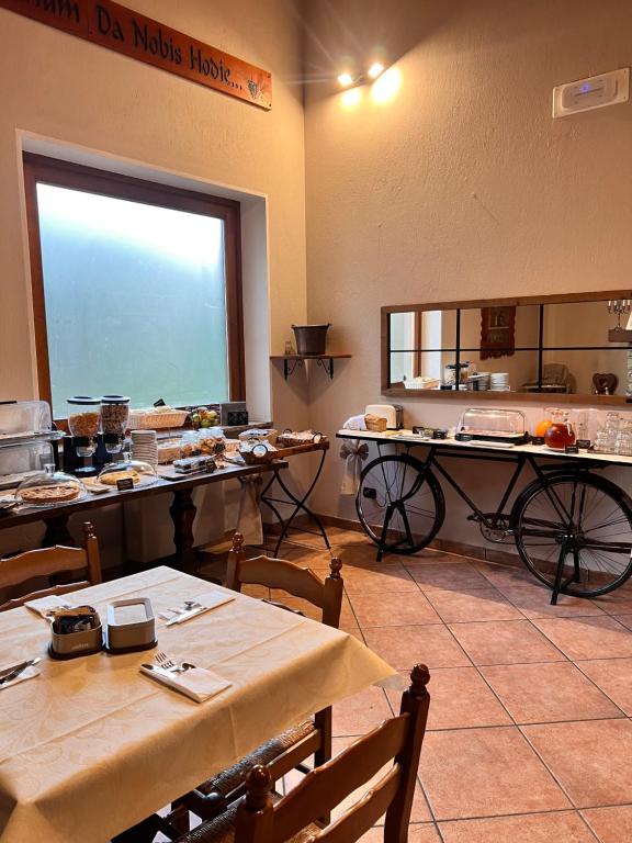 een keuken met tafels en stoelen in een kamer bij Fell Hotel in Susa