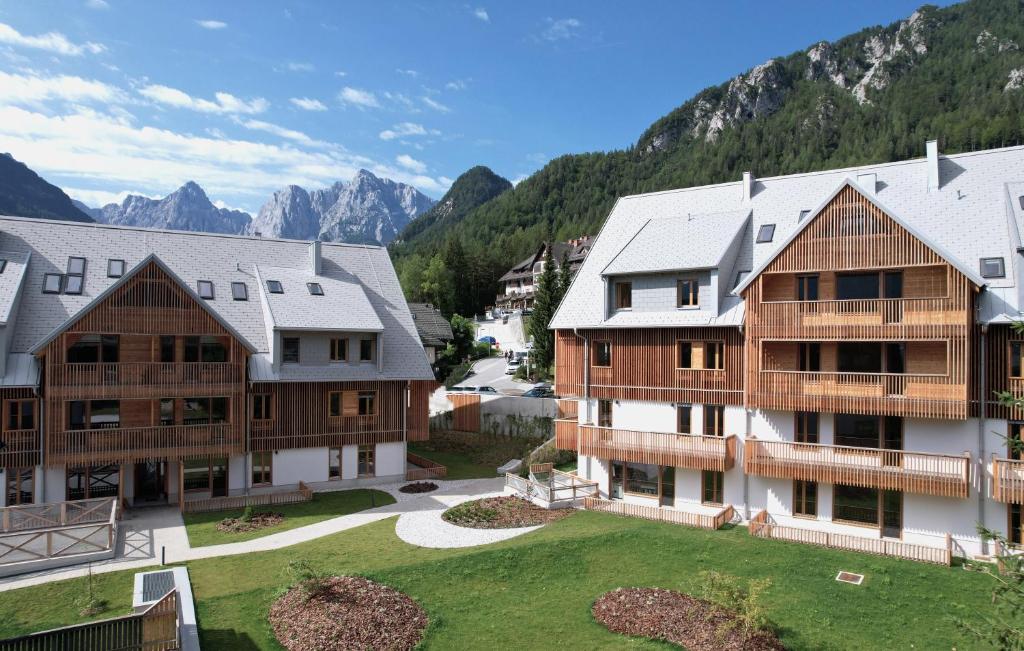 une vue aérienne de deux bâtiments avec des montagnes en arrière-plan dans l'établissement Goldhorn Chalet, à Kranjska Gora