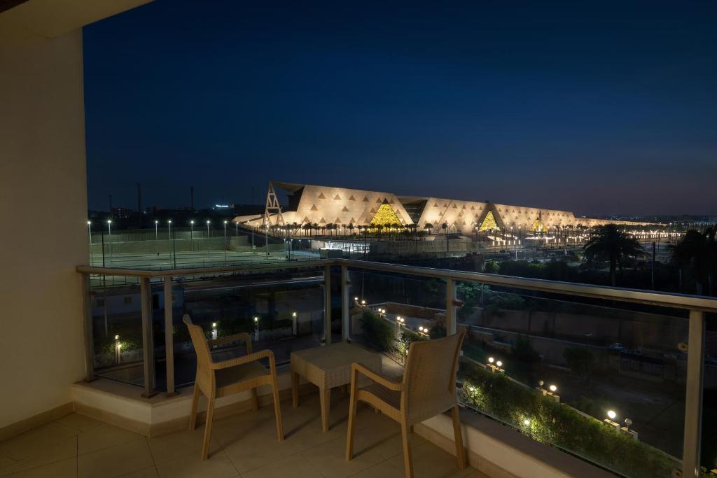 einen Balkon mit Stühlen und Blick auf ein Stadion in der Unterkunft Steigenberger Pyramids Cairo in Kairo