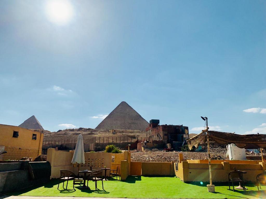 einen Blick auf die Pyramiden von Giza mit Tischen und Stühlen in der Unterkunft Sidi Hamad Pyramids View in Kairo