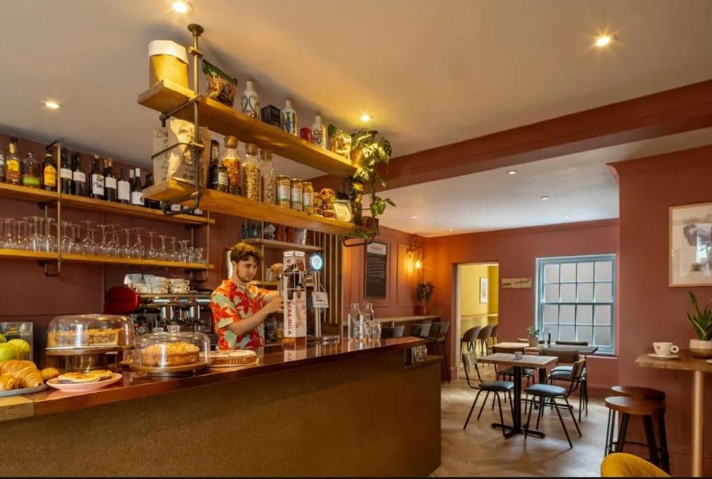 a woman standing behind a bar in a restaurant at Lento Apartment in Winchester