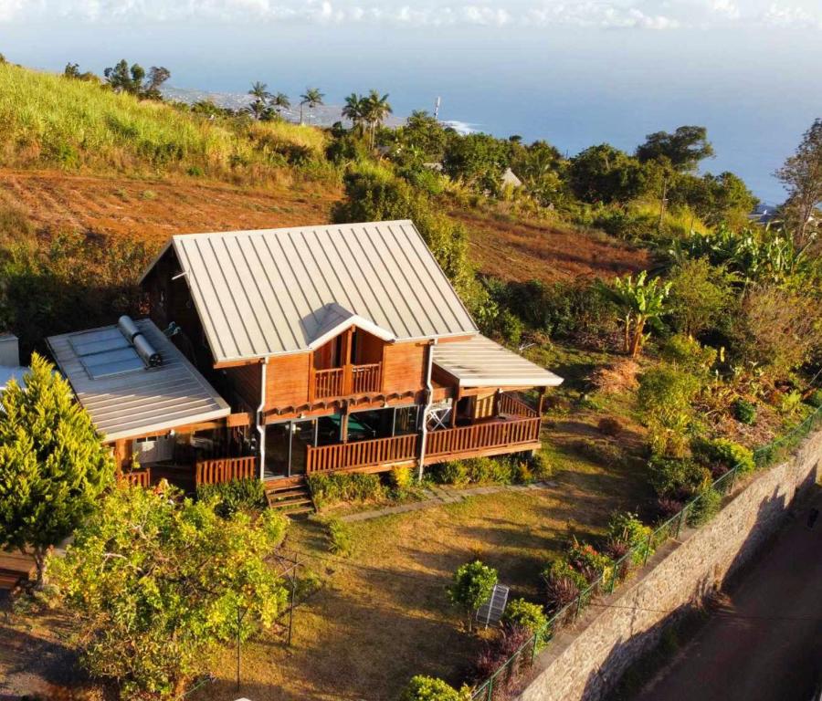 een huis op een heuvel met de oceaan op de achtergrond bij Chalet des parapentes in Saint-Leu