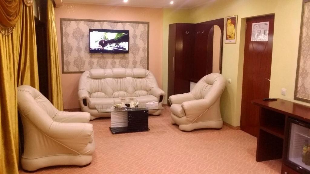 - un salon avec deux chaises et une télévision dans l'établissement Byblov Rooms Boutique, à Bucarest