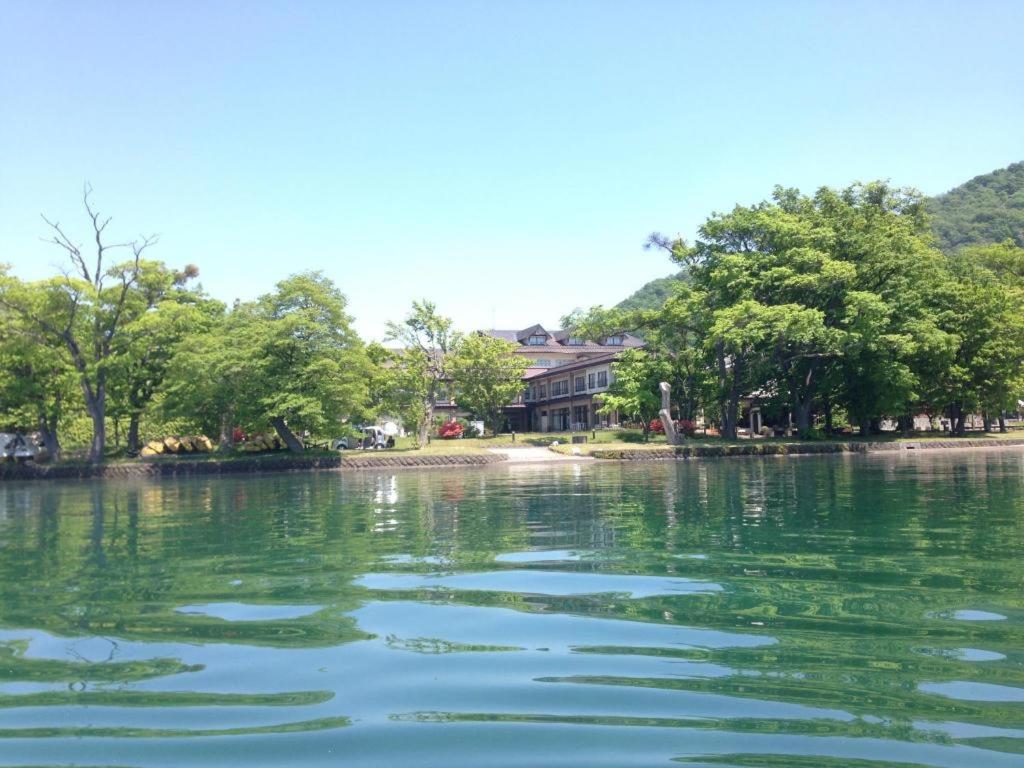 una gran masa de agua con una casa en el fondo en Towadako Lakeside Hotel, en Towada