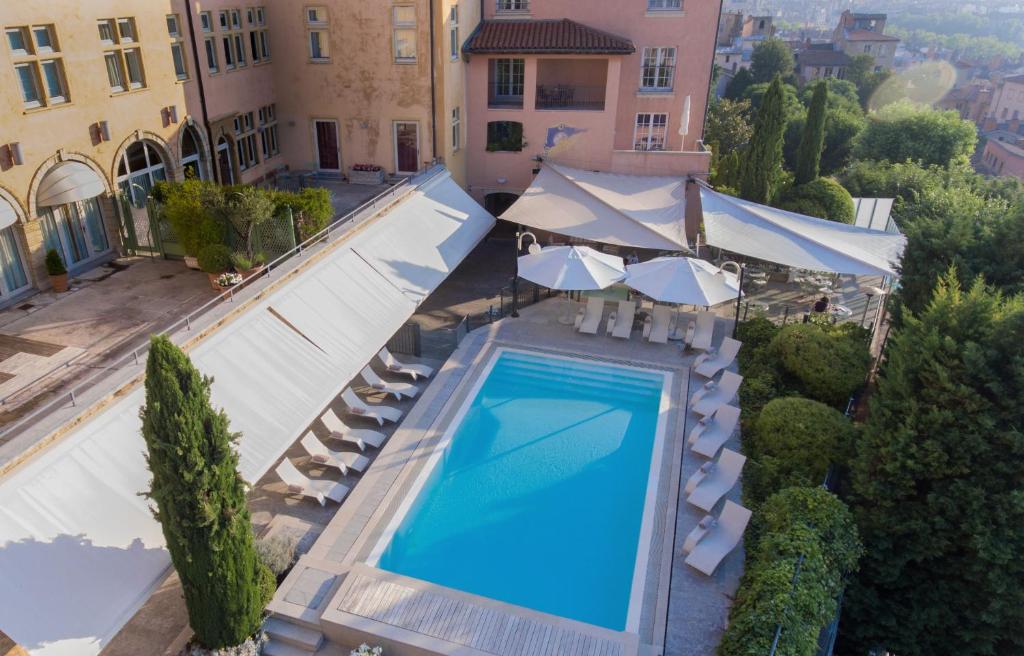 an overhead view of a swimming pool with umbrellas at Villa Florentine in Lyon