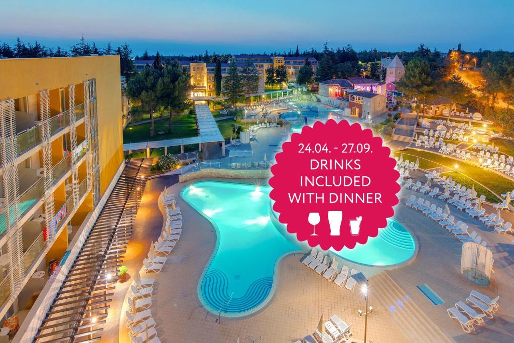 a resort pool with a sign that reads drinks included with dinner at Hotel Garden Istra Plava Laguna in Umag