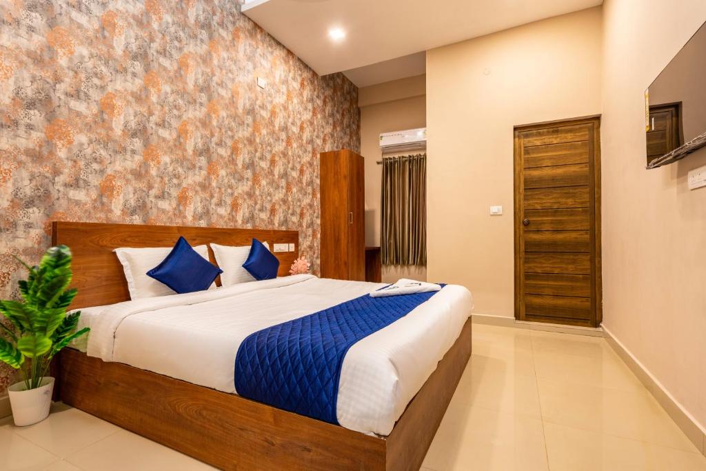 1 dormitorio con 1 cama grande con almohadas azules en Yaad Residency, en Ernakulam