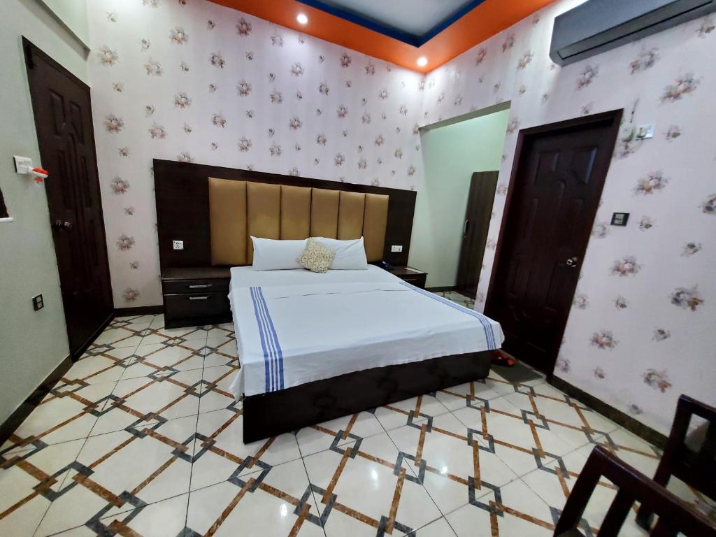 a bedroom with a large bed in a room at Diplomat Inn Hotel in Karachi