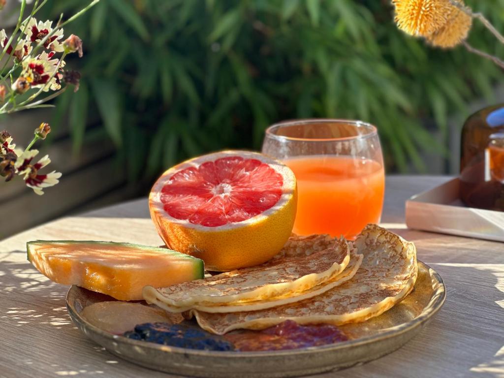 einen Teller mit Obst und ein Glas Orangensaft in der Unterkunft Spar Hotel Gårda in Göteborg