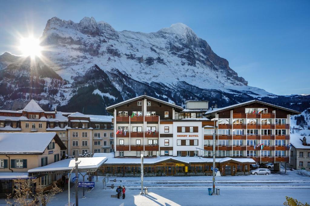 hotel z pokrytą śniegiem górą w tle w obiekcie Derby Swiss Quality Hotel w mieście Grindelwald