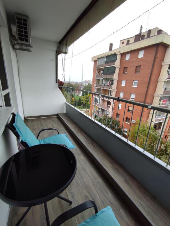 balcón con mesa y sillas y vistas a un edificio en Ema Apartmani, en Vinkovci