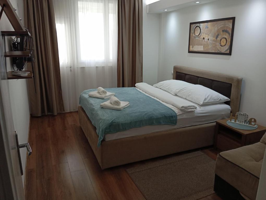 - une chambre avec un lit et des serviettes dans l'établissement Apartman Leon Lux, à Leskovac