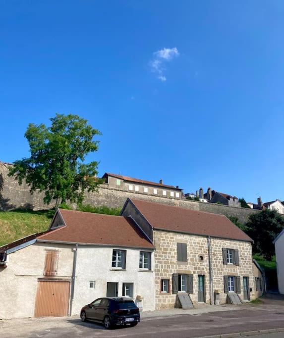 un'auto parcheggiata di fronte a un edificio in pietra di Villa Inès a Langres