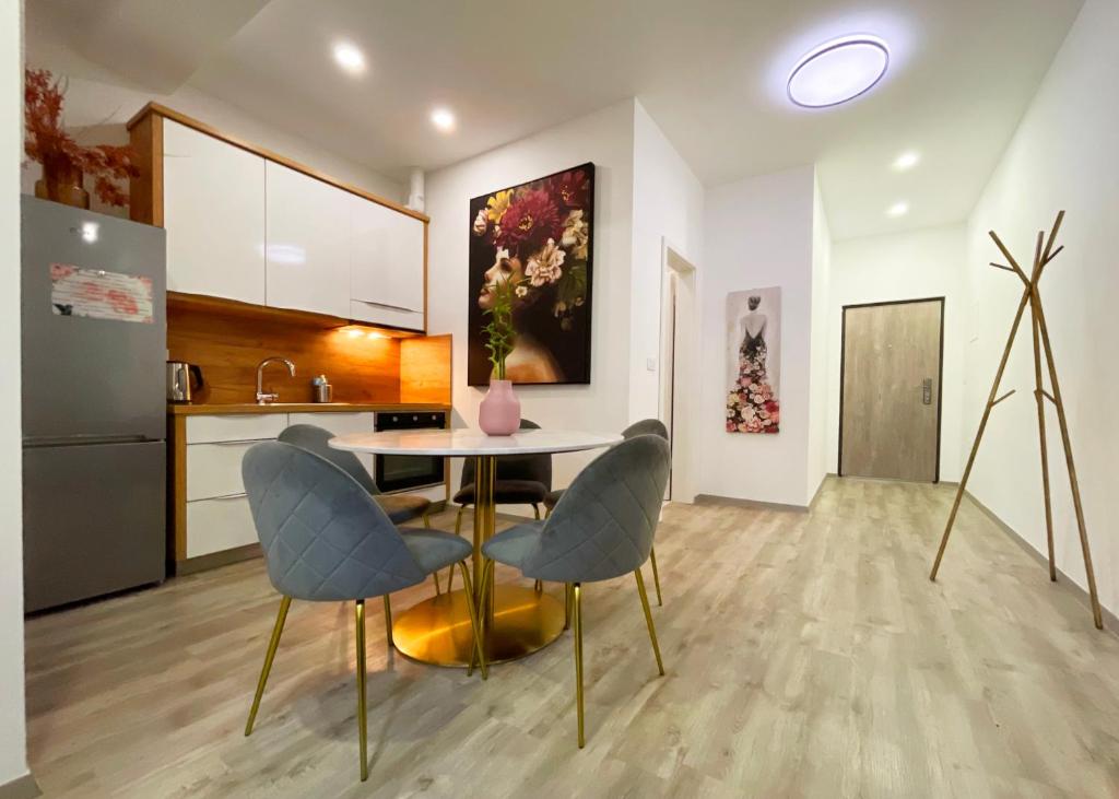 een keuken met een tafel en stoelen in een kamer bij The Maze Apartment in Ljubljana