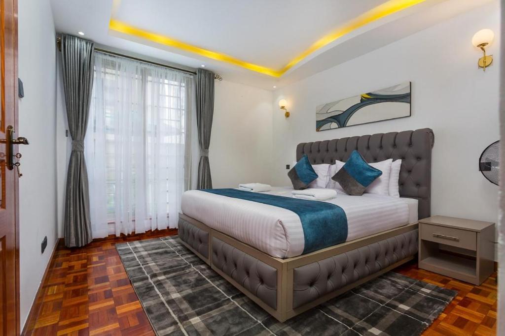 - une chambre avec un grand lit dans l'établissement Tranquil Residences, à Nairobi