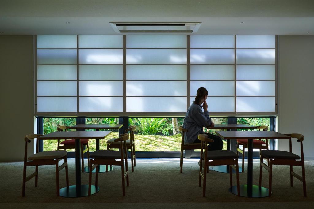 a man sitting at a table in front of a window at Shin-Osaka Station Hotel in Osaka