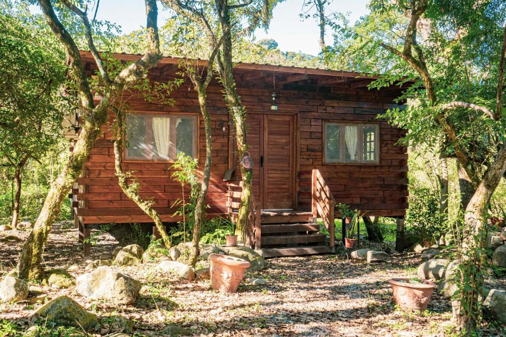 a log cabin in the woods with trees at Cabaña Win en el Bosque, RUNA YAKU in San Lorenzo