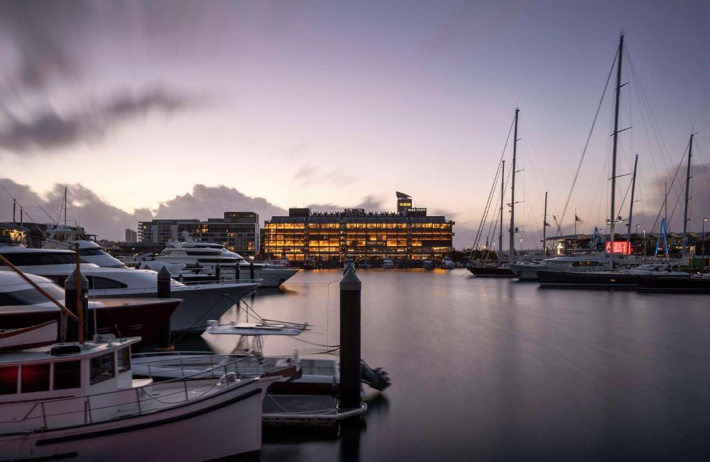 オークランドにあるPark Hyatt Aucklandの夕暮れ時のマリーナに停泊する船団