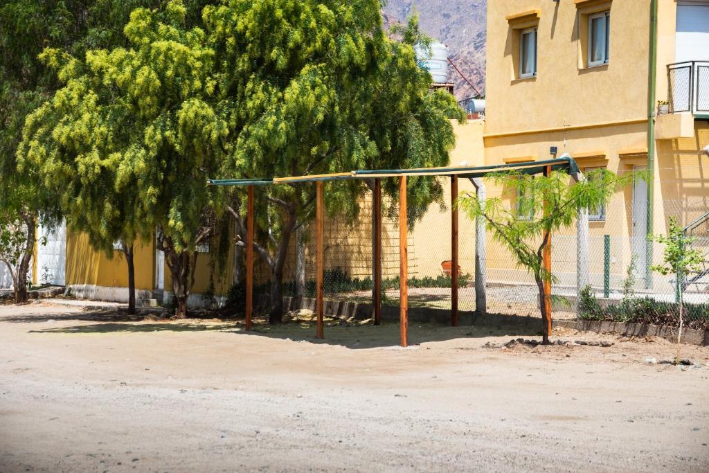 una jaula de bateo delante de un árbol y un edificio en Departamentos PASEO DE LAS VIÑAS, CAFAYATE, en Cafayate