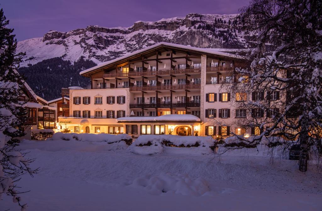 un gran edificio en la nieve por la noche en Hotel Adula, en Flims