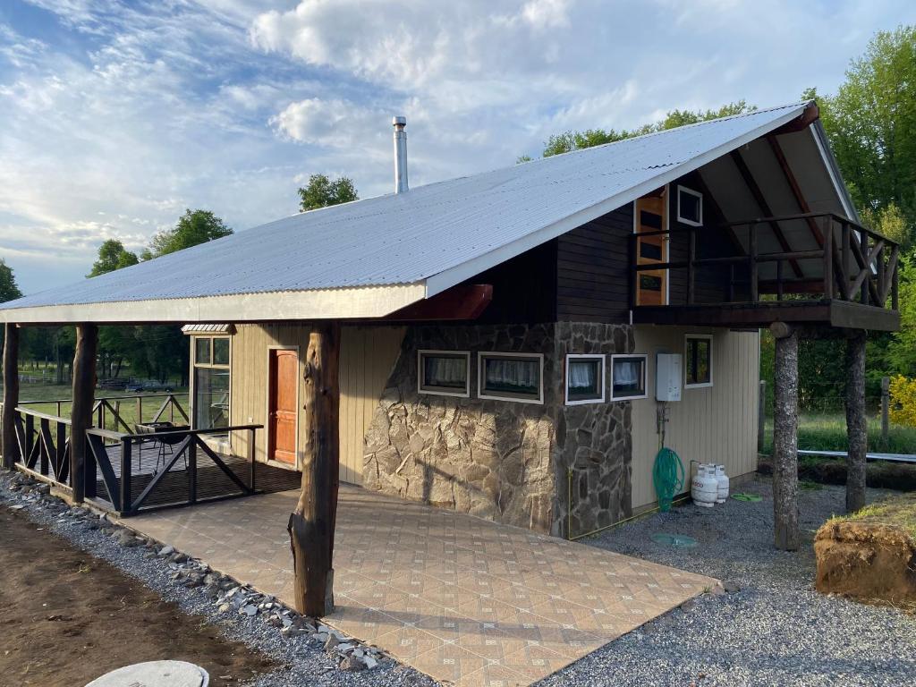 una casa con techo de gambrel y patio en Cabañas El Tronco Viejo, en Curacautín