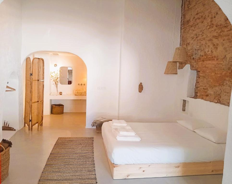 Cette chambre blanche dispose d'un lit et d'un couloir. dans l'établissement Casas Velhinhas - Apartº Aconchego e Apartº Calmaria, à Estremoz