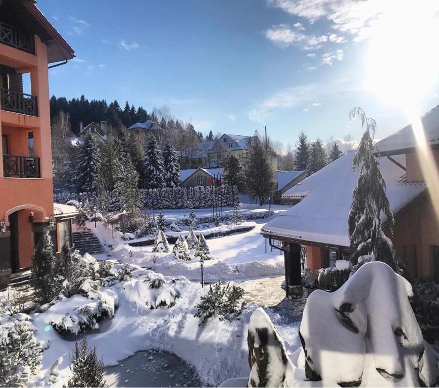 um quintal coberto de neve ao lado de um edifício em СПА-Готель "RESPECT" em Skhidnitsa