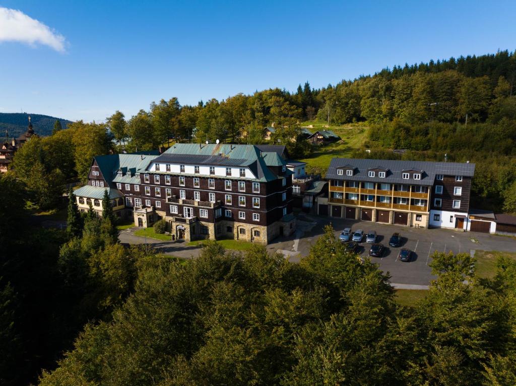 une vue aérienne sur un bâtiment avec un parking dans l'établissement Hotel Tanecnica, à Pustevny