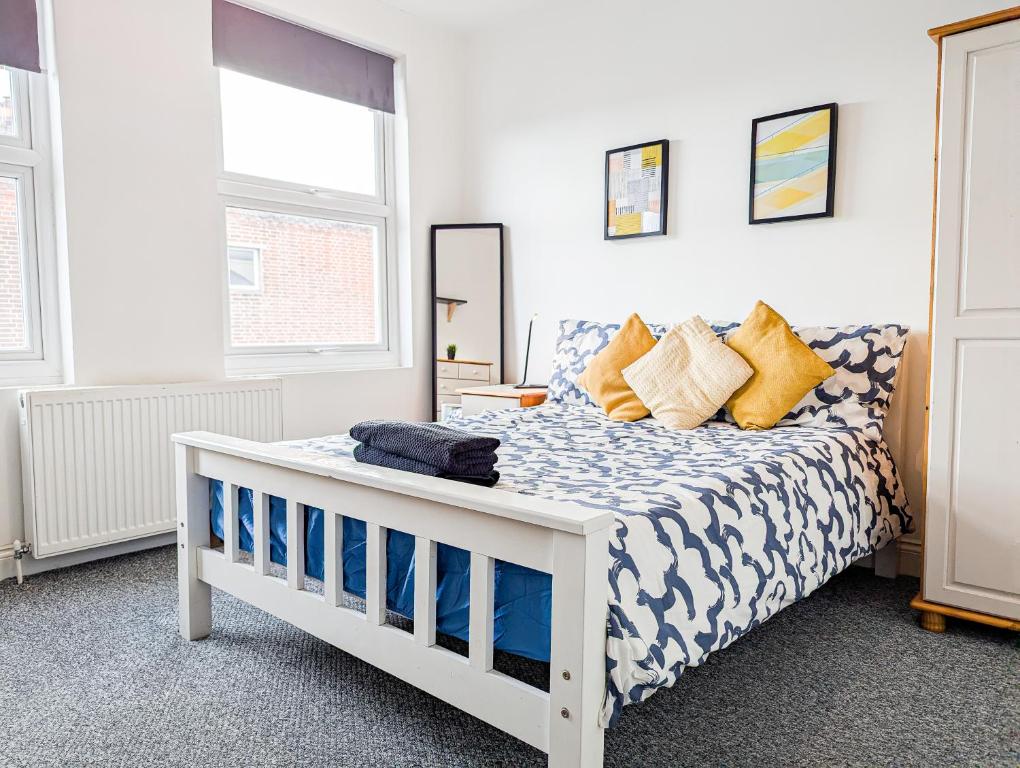 una camera da letto con un letto bianco con lenzuola blu e bianche di Central Southsea Guest House a Portsmouth