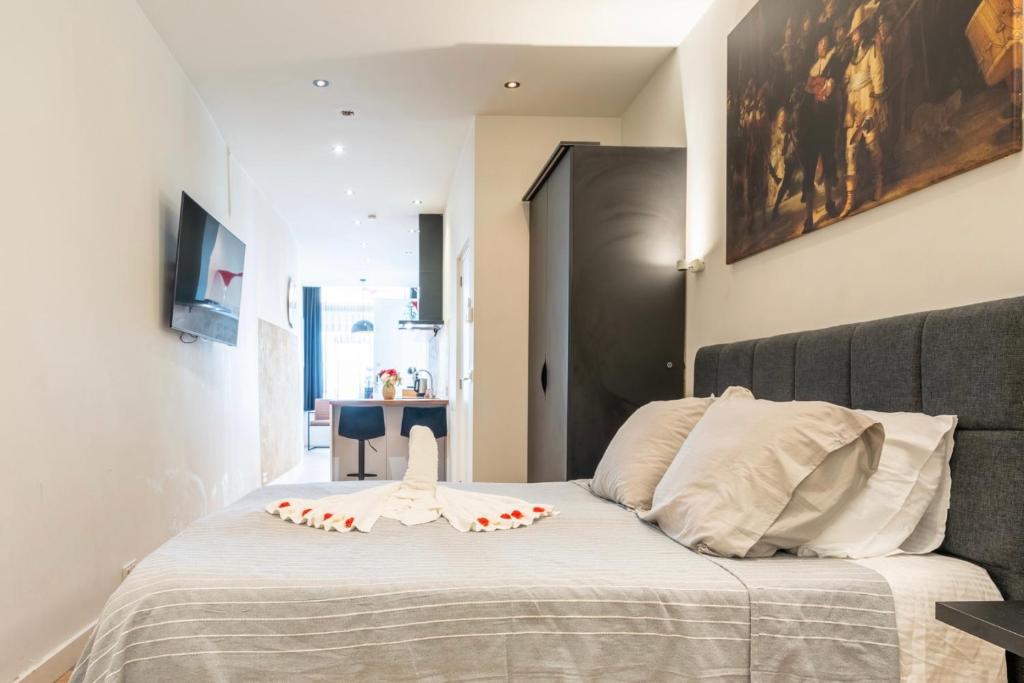 Stylish studio in the heart of Breda city center في بريدا: غرفة نوم بها سرير عليه زهور