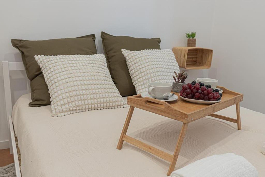 einen Couchtisch mit einem Tablett mit Obst auf dem Bett in der Unterkunft Duplex em Baía do Seixal in Seixal