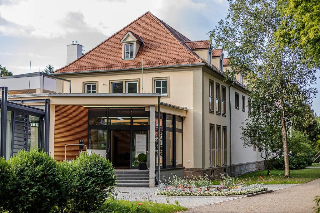 une grande maison avec un toit dans l'établissement Hotel Kurhaus Bad Bocklet, à Bad Bocklet