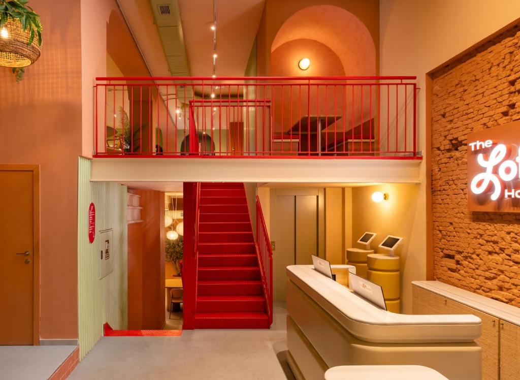 um edifício com uma escada vermelha num quarto em The Loft Hostel Lavapies em Madrid