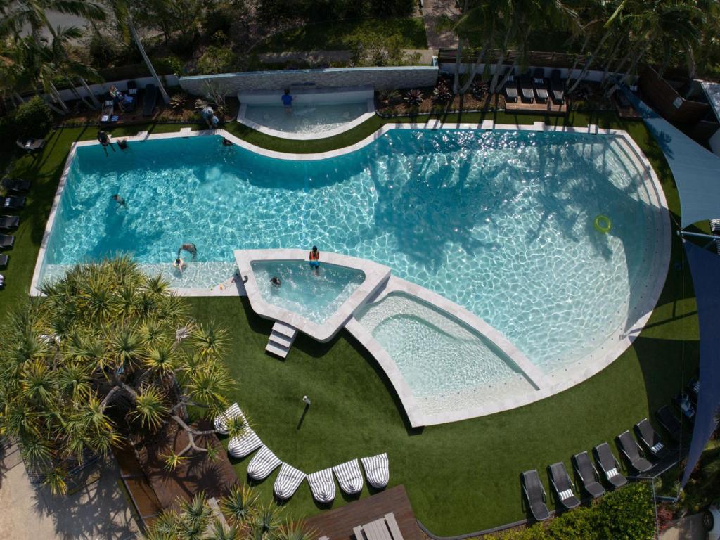 an overhead view of a swimming pool with chaise lounge chairs at Atlantis Marcoola in Marcoola