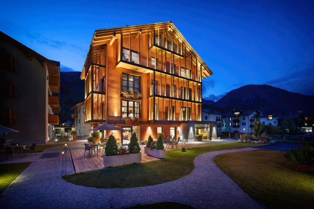 Hotel Roberta Alpine Adults only في ليفينو: مبنى كبير في مدينة في الليل