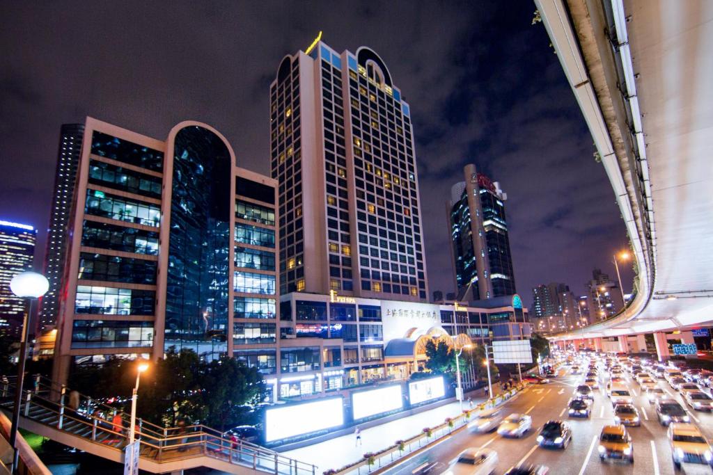 eine Stadt nachts mit Autos auf einer belebten Straße in der Unterkunft Hotel Equatorial Shanghai in Shanghai