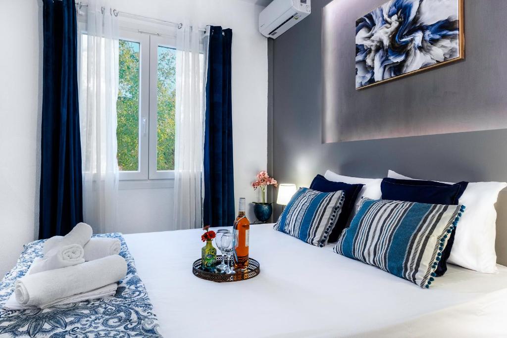 a white bed with blue and white pillows and a window at MarGio Bay in Limenas