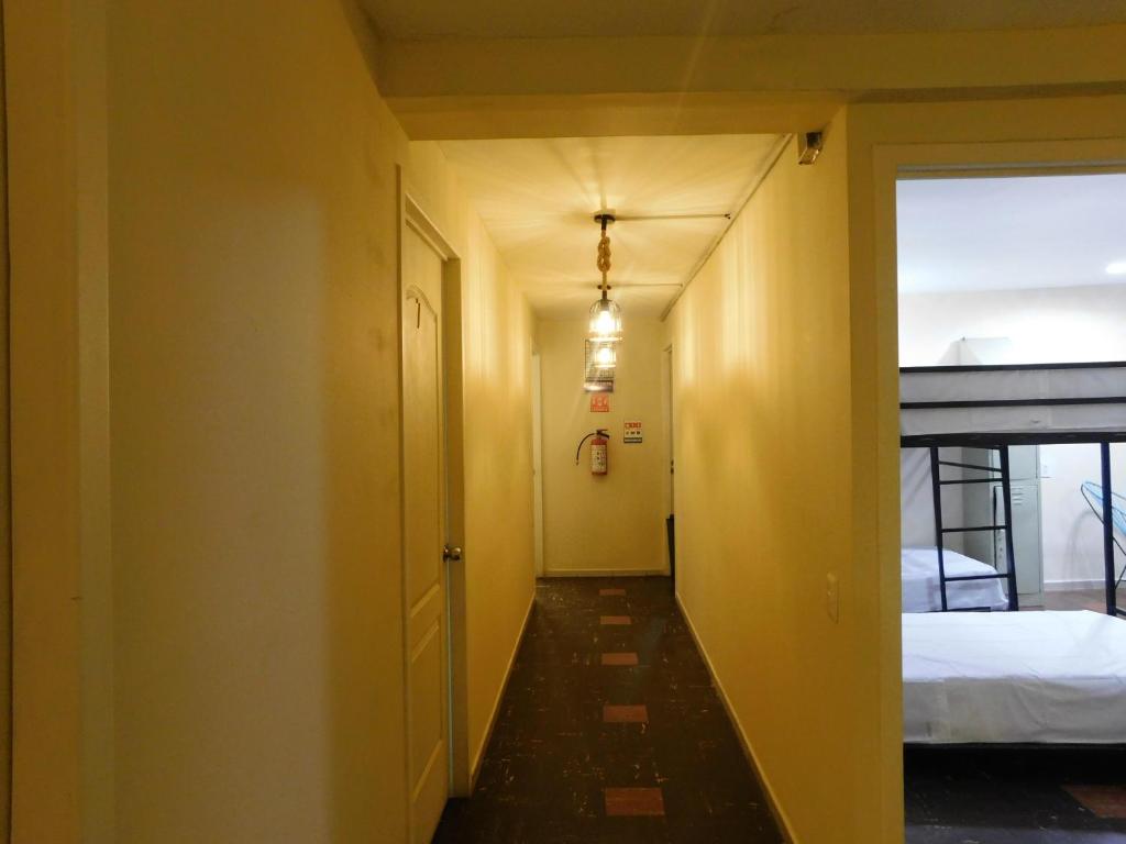 a hallway leading to a bedroom with a bed at Casa Talavera Hostel in Mexico City