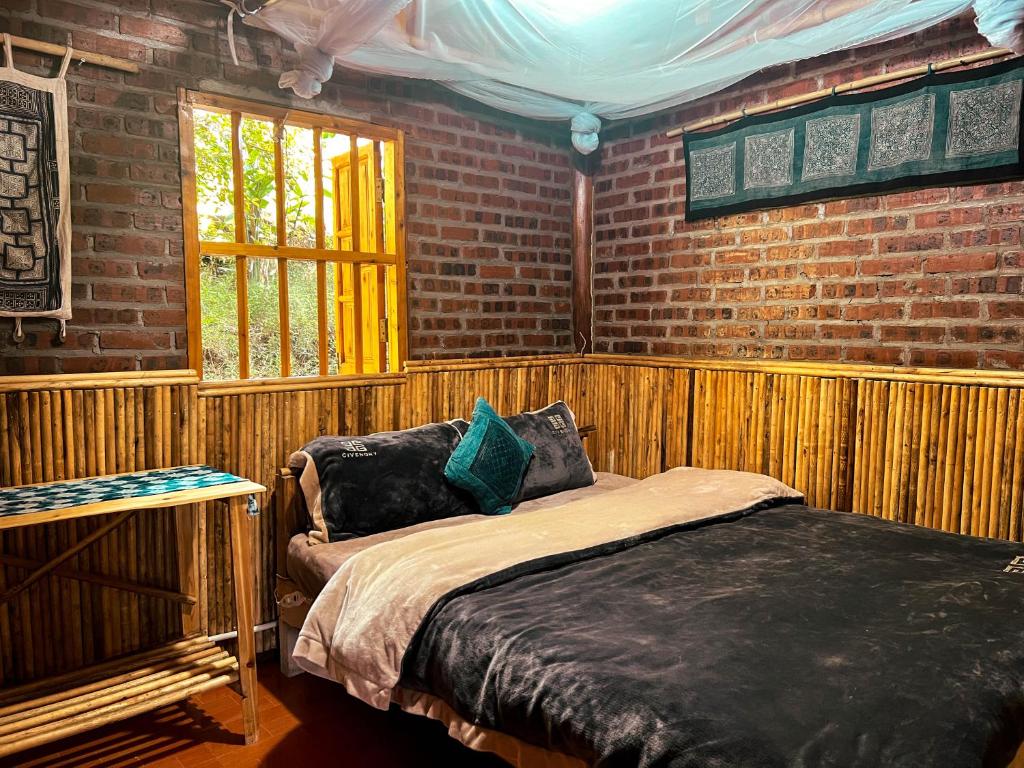 a bed in a room with a brick wall at Sapa's soul hillside in Sa Pa