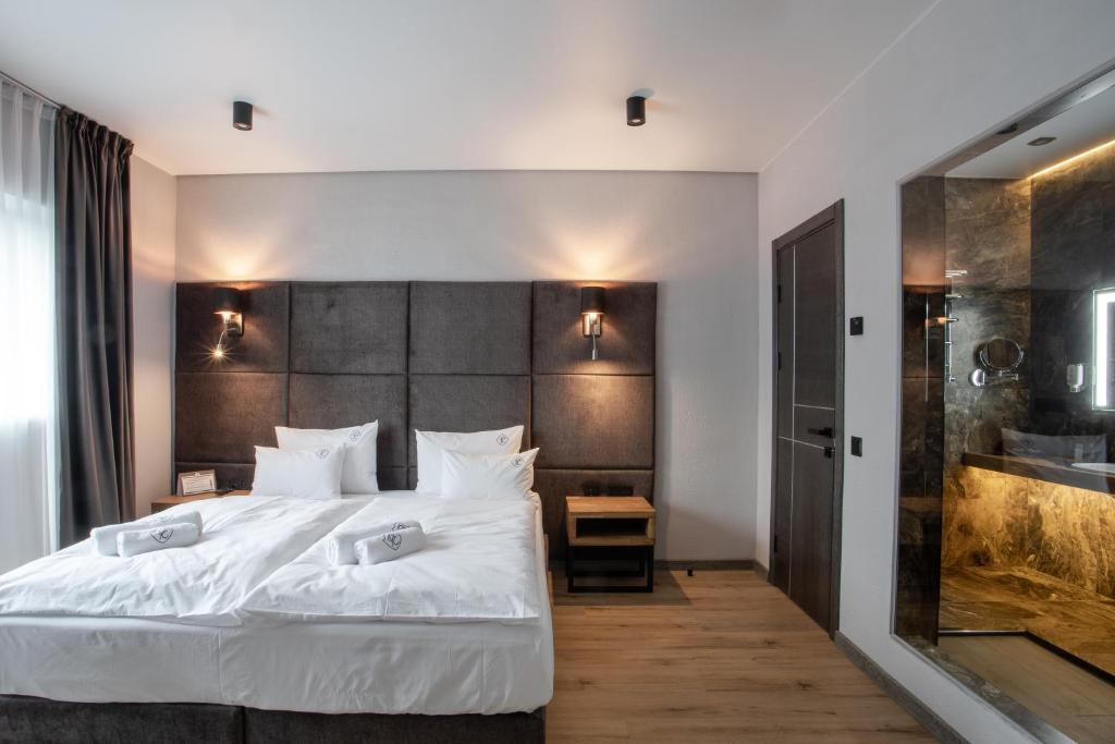 - une chambre avec un grand lit blanc et une salle de bains dans l'établissement Premium Club SPA, à Bukovel