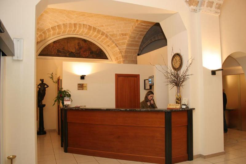 a woman sitting at a reception desk in a building at Hotel Adria in Bari