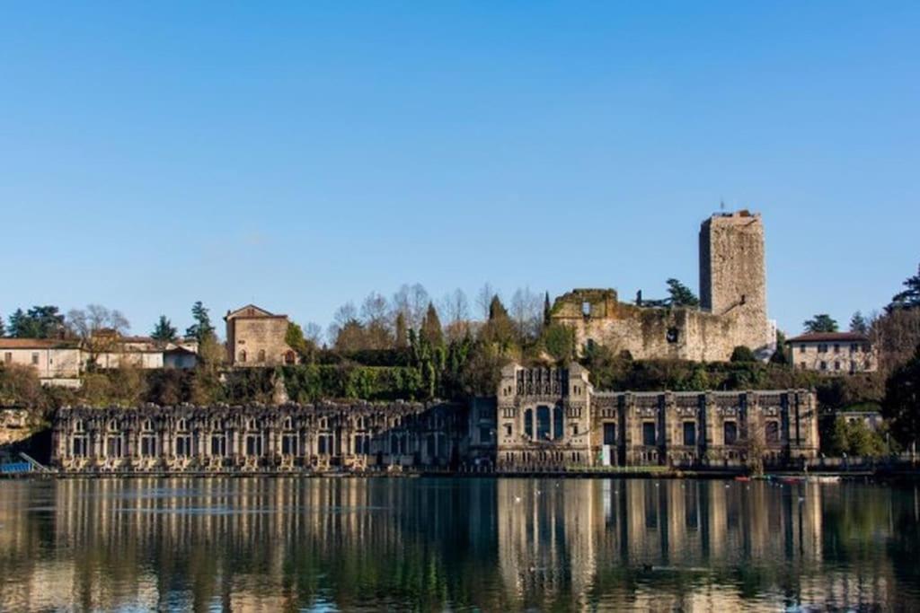 um castelo sobre a água em frente a uma cidade em Casa di Damiano em Vaprio dʼAdda