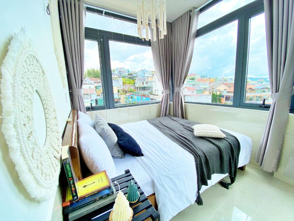 - une chambre avec un lit et une grande fenêtre dans l'établissement Lantana Homestay, à Đà Lạt