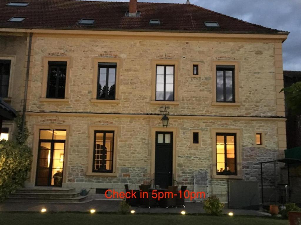 uma grande casa de tijolos com luzes nas janelas em Les Tourelles em La Tour-du-Pin